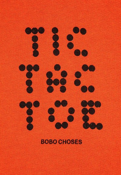 Zwarte stippenletters die "TIC TAC TOE" spellen boven de merknaam "BOBO CHOSES" op een oranje textuurstof achtergrond.
