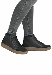 Sneakers alte nere con finitura in pelle texture, dotate di cerniera laterale, chiusura con lacci e suola in gomma con contrasto color cuoio.
