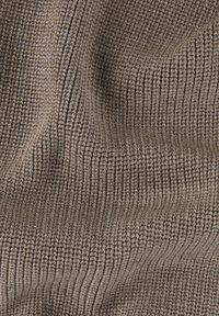 Tissu marron à côtes avec une surface texturée, présentant des rayures verticales et un aspect tricoté doux. Convient pour les vêtements ou le rembourrage.