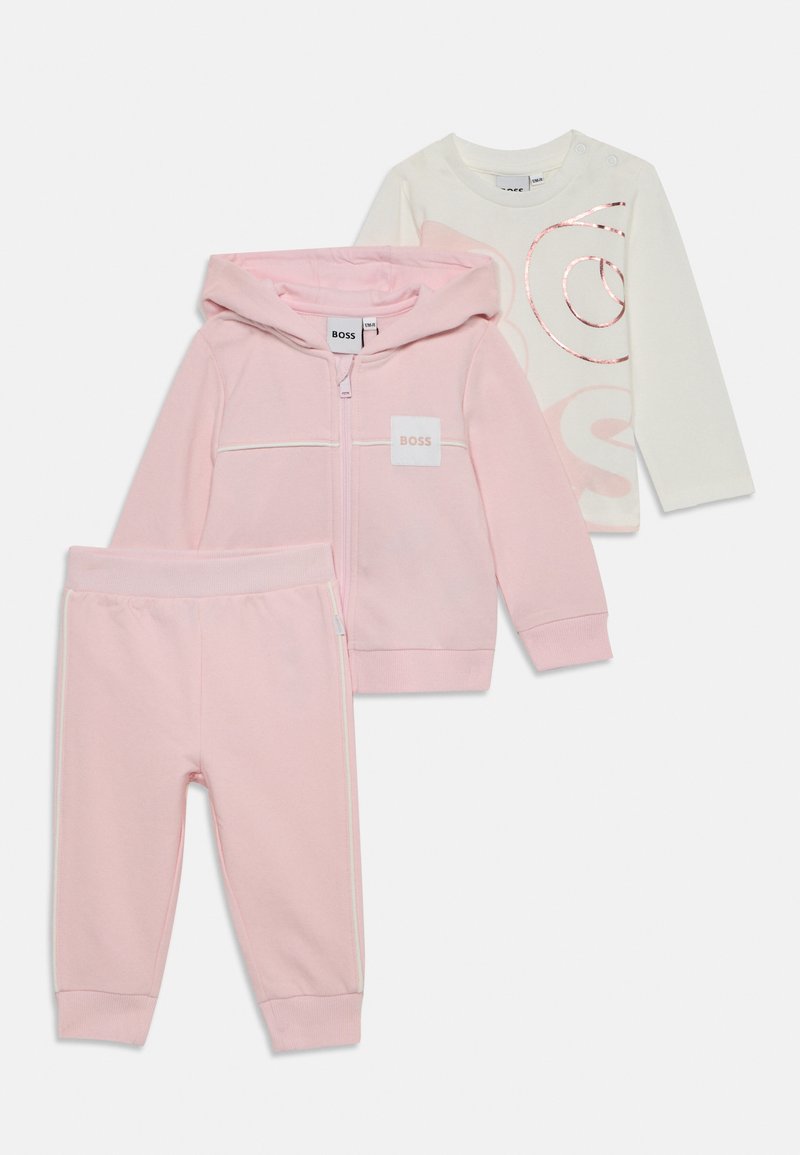 Completo per bambini in tre pezzi: una felpa rosa con zip, pantaloni della tuta rosa e una maglietta bianca a maniche lunghe con logo rosa. Tessuto morbido e casual.