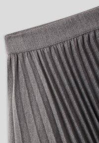 Tessuto grigio a pieghe con una morbida texture e una cintura larga, dotato di linee verticali per un tocco di dettaglio e design.