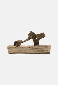 Brune swede plattform sandaler med vevd jute-detalj, med justerbare stropper og runde øyelets aksenter. Flat gummisåle.