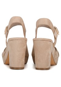 Beige suède hoge sandalen met brede banden en een enkelgesp, met een stevige blokhak en een gladde textuur.