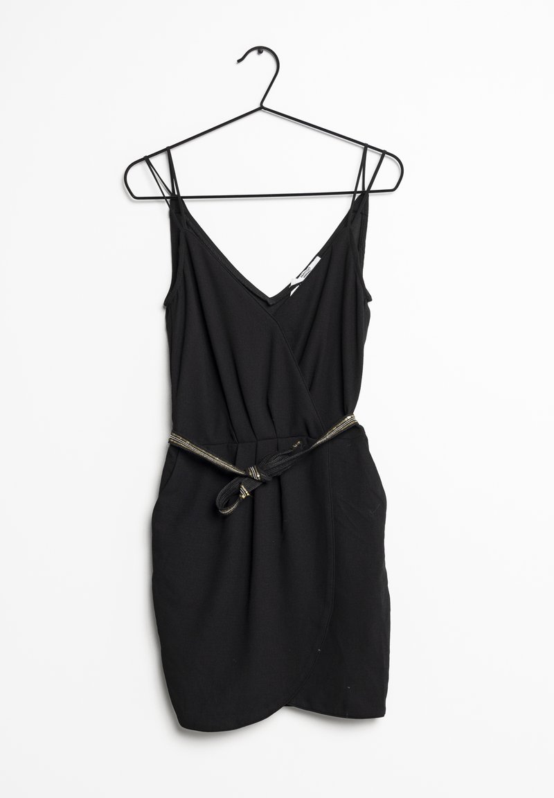 Vestido negro sin mangas con escote en V, diseño envolvente y un cinturón de tela a juego con un acento metálico. Textura suave. Cuelga de un gancho negro.