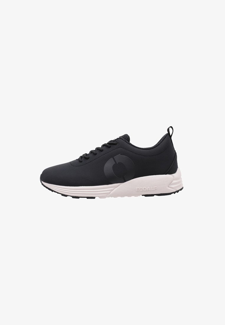 Zapatilla deportiva negra con una parte superior lisa y transpirable, suela blanca y un diseño de logo sutil. Presenta cordones y una pestaña de agarre en la parte trasera.