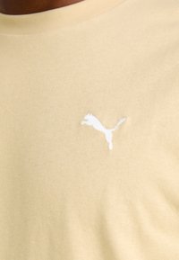 Lichtgele katoenen T-shirt met een wit geborduurd logo van een springende puma op de linkerborst, met een ronde hals.