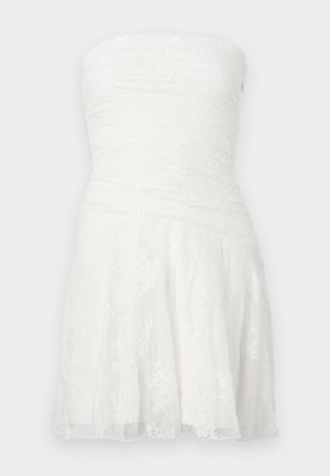 Fehér pántnélküli ruha, ráncolt mellrésszel, csipke részletekkel és bővülő szoknyával. Könnyű anyagból készült, texturált felülettel.