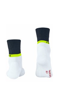 Calzini bianchi con un gambale a coste nere, caratterizzati da una fascia gialla neon e testo rosso. Texture liscia, progettati per un uso atletico.