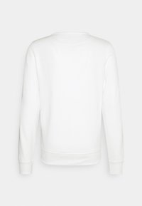 Sweat-shirt blanc uni à manches longues vu de dos avec poignets et ourlet côtelés sur fond gris clair.