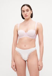 Rosa BH mit glatten Cups, Spitzenakzenten und verstellbaren Trägern. Weißer String mit Spitzenbesatz. Beide haben eine weiche Textur und definierte Formen.