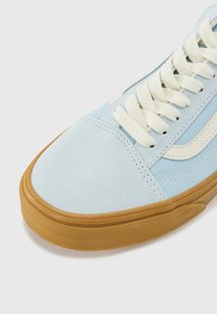 Tenisi din suede albastru deschis cu talpă din cauciuc, având șireturi crem și dungi laterale, prezentând un design de profil jos.