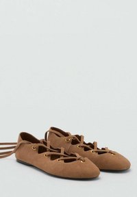 Încălțăminte ballerine din suede, de culoare maro, cu ochiuri aurii și șireturi încrucișate. Vârf rotund și talpă plată, concepute pentru confort și ușurința la purtare.