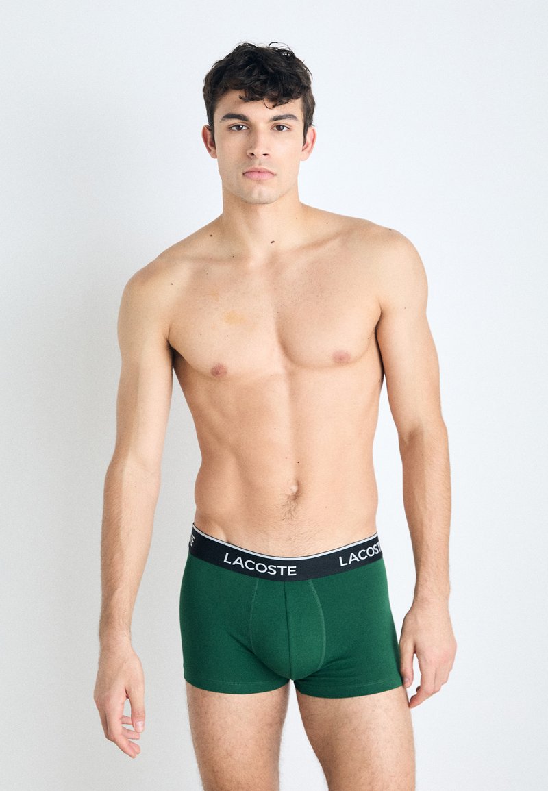 Groene katoenen boxershorts met een zwarte tailleband waarop het Lacoste-logo staat. Het ontwerp is aansluitend, met een gladde textuur en zonder patronen.