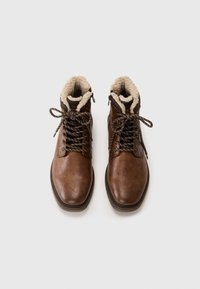 Braune Lederstiefeletten mit strukturiertem Finish, ausgestattet mit einem Kunstfellfutter, Metallösen und braunen Schnürsenkeln.