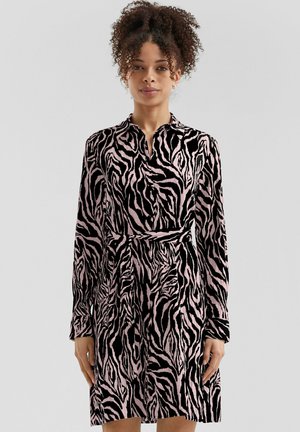 Robe à manches longues en tissu doux avec un motif zèbre rose et noir, dotée d'un col et d'une taille nouée pour une silhouette ajustée.