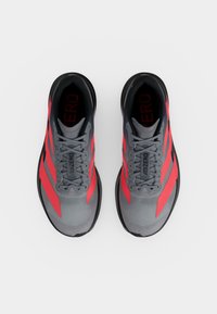 Ζευγάρι γκρι και κόκκινα παπούτσια για τρέξιμο Adidas Adizero, θέα από πάνω, που δείχνει κορδόνια και σήμανση στη γλώσσα και στην εσωτερική σόλα.