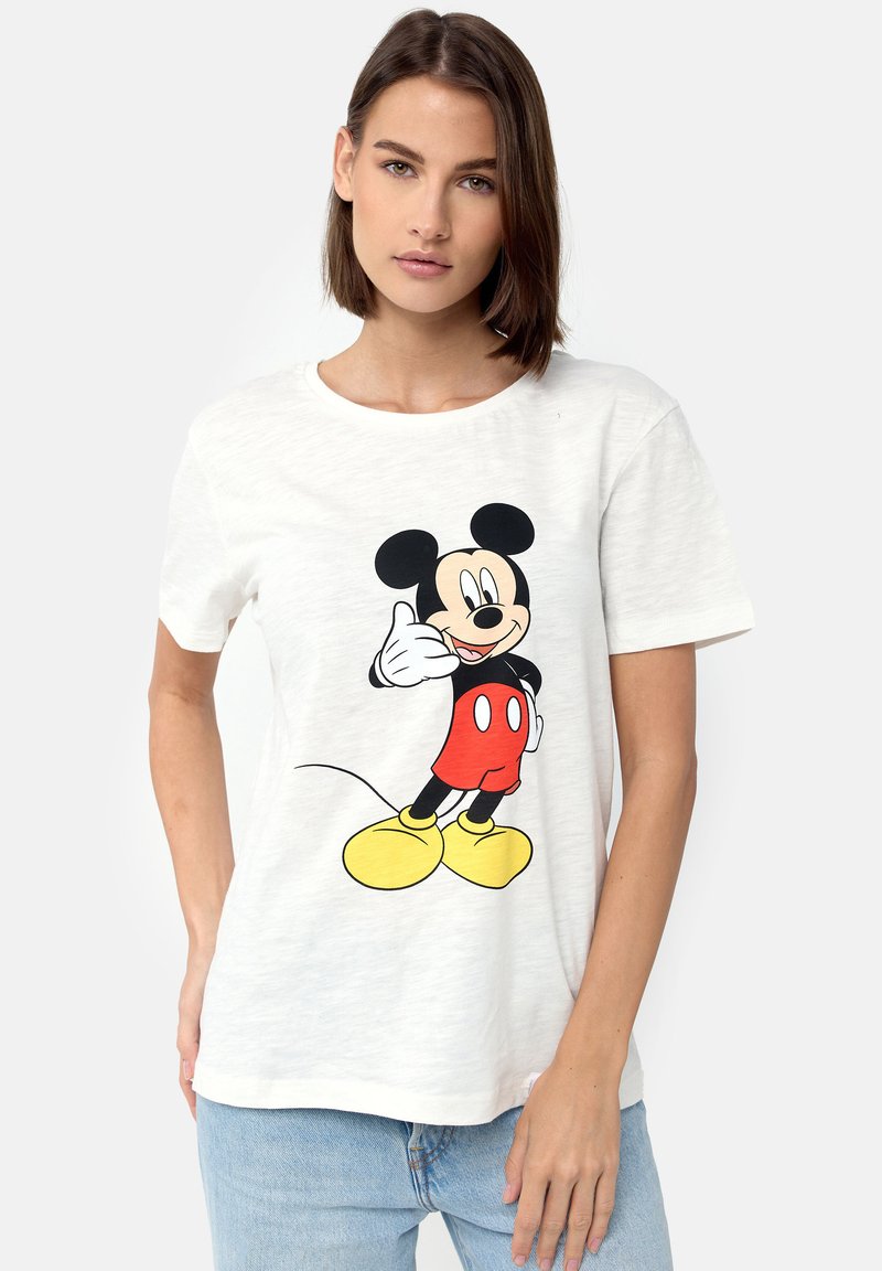 Hvid bomulds T-shirt med et grafisk print af en smilende tegneseriemus i røde shorts og gule sko, præsenteret mod en neutral baggrund.