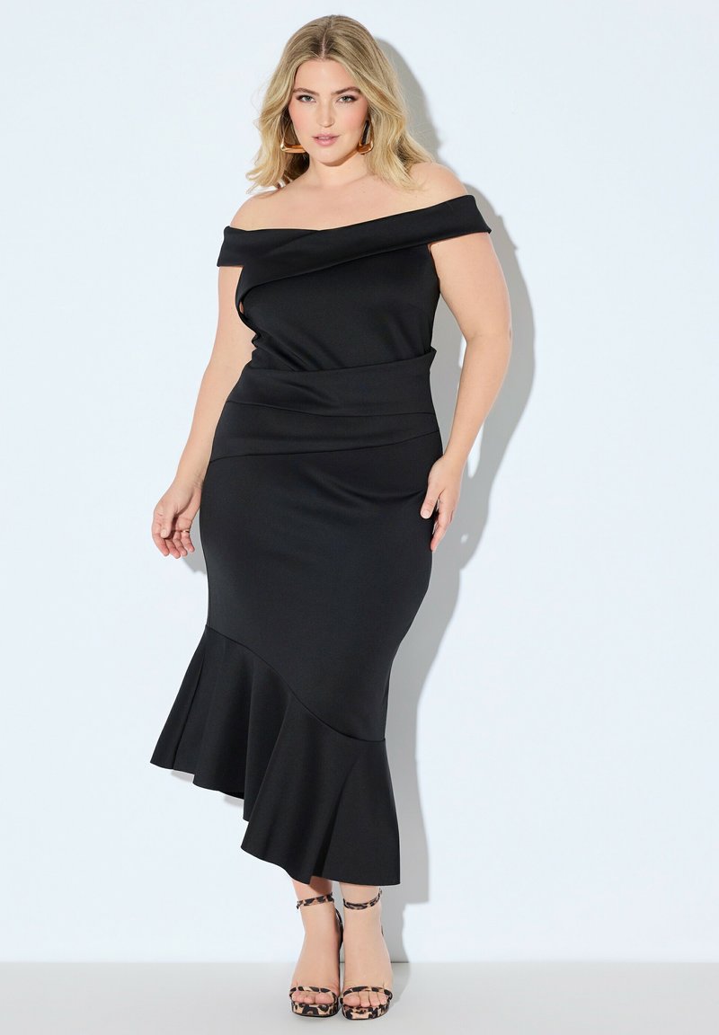 Czarna sukienka odsłaniająca ramiona z dopasowanym gorsetem, rozkloszowanym dołem i gładką teksturą. Do tego sandały na paskach w wzór pantery.