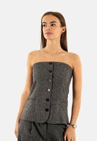 Top senza spalline, grigio scuro, con motivo a pied de poule e una silhouette aderente, caratterizzato da una chiusura con bottoni sul davanti e due tasche laterali.