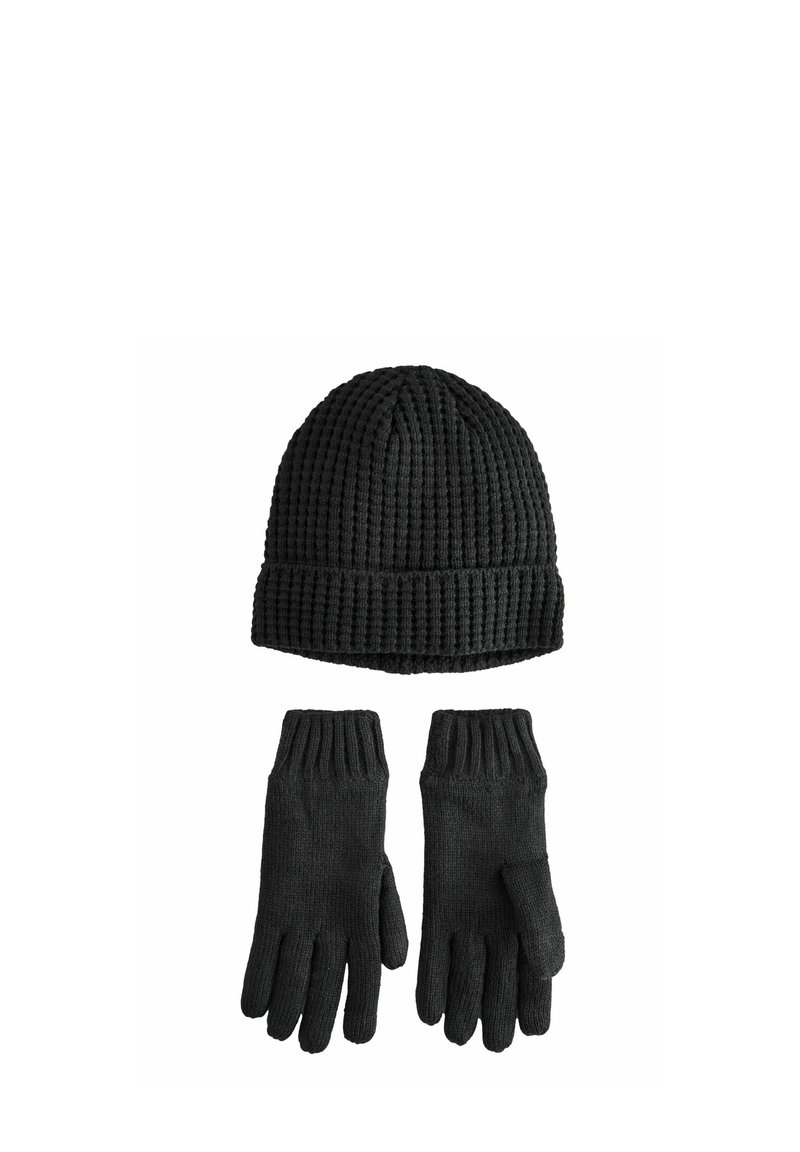 Schwarzes Strickmütze- und Handschuhset. Die Mütze hat eine vertikale Rippung, während die Handschuhe eine strukturierte Oberfläche und gerippte Bündchen besitzen.