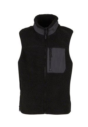 Must mustriga vest, millel on kõrge krae, täispikad lukud ja hall tasku. Tekstuuriga kangas, millel on pehme ja koheline välimus.