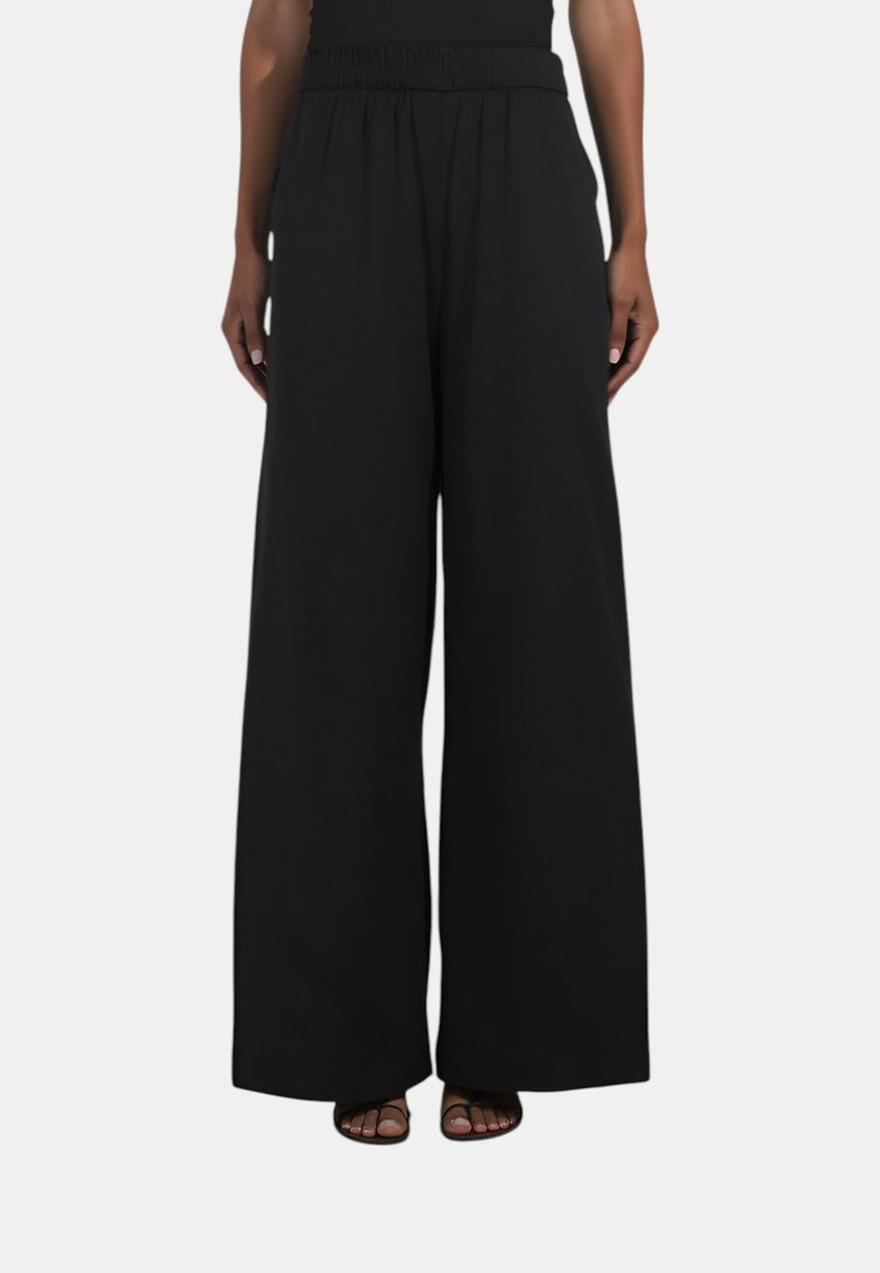 Pantaloni neri a gamba larga con vita elastica, realizzati in un tessuto morbido. Presentano una vestibilità morbida, offrendo comfort e libertà di movimento.