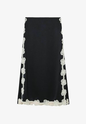 Zwarte rok met een gladde textuur, voorzien van crèmekleurige bloemenuitvoering van kant langs de zijkanten en zoom, wat zorgt voor een contrasterend designelement.