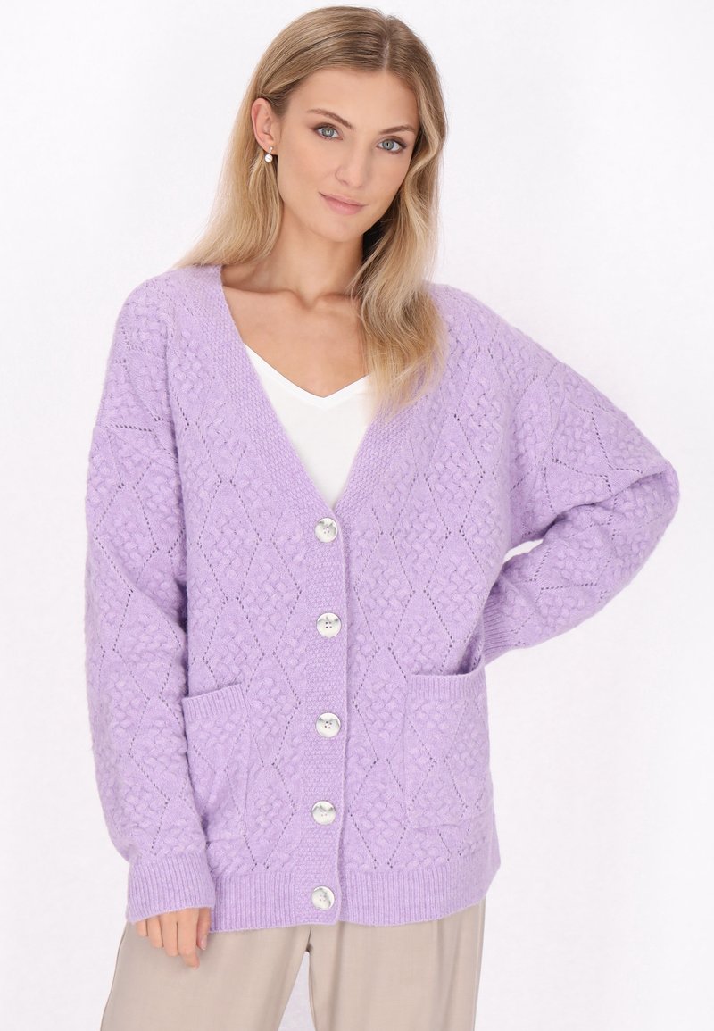Fialový pletený cardigan s diamantovým vzorem, výstřihem do V, se dvěma řadami knoflíků a dvěma předními kapsami. Měkká textura a žebrované manžety a lem.