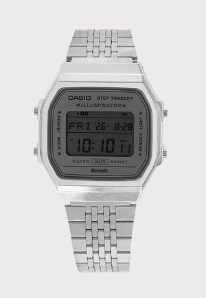 Silberne Casio Digitalarmbanduhr mit Metallgliederarmband, die Zeit, Datum und Schrittzählerfunktionen auf dem rechteckigen Bildschirm anzeigt.