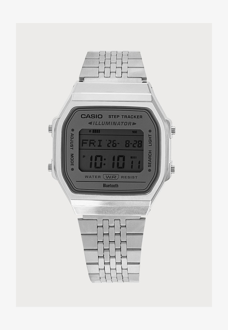 Ασημένιο ψηφιακό ρολόι χειρός Casio με μεταλλικό μπρασελέ, που εμφανίζει ώρα, ημερομηνία και λειτουργίες παλμογράφου στην ορθογώνια οθόνη.