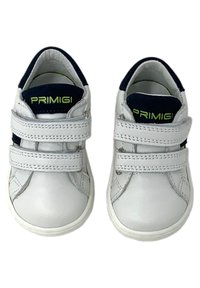 Sneaker in pelle bianca con accenti blu navy, doppie fasce in Velcro, punta arrotondata e suola texturizzata. Nome del marchio "Primigi" in verde sulla linguetta.