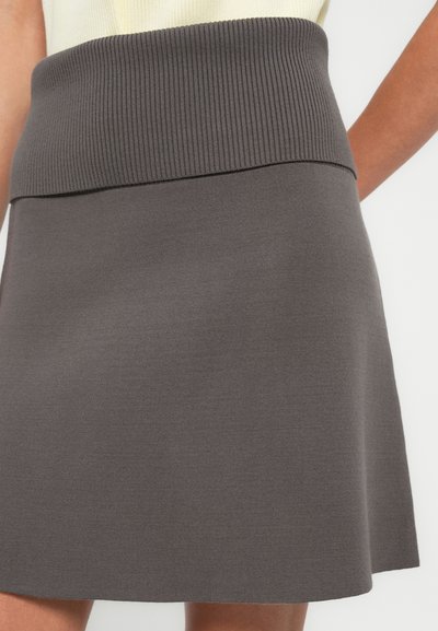 Jupe en maille grise avec une ceinture côtelée, s'évasant doucement à l'ourlet. Le matériau semble doux et lisse avec peu de détails.