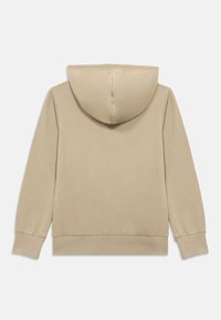 Μπεζ φούτερ με κουκούλα, με λεία υφή, μακριά μανίκια και ριμπ μανσέτες. Η πλάτη είναι απλή χωρίς επιπλέον διακοσμητικά.