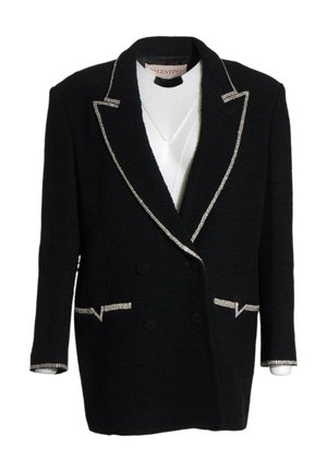 Zwarte dubbelgeknoopte blazer met zilverkleurige bies op revers, zakken en manchetten over een witte top, met Valentino-label binnenin de kraag.