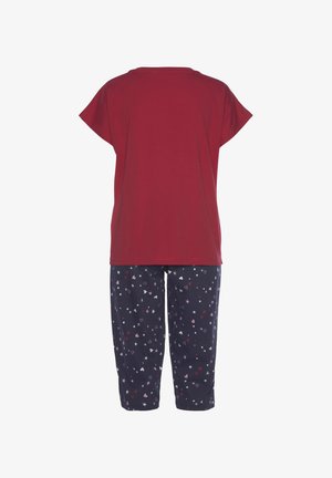 Red short-sleeve top with a round neckline paired with navy pants featuring a pattern of hearts and stars in pink and white.