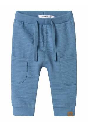 Pantaloni per bambini in maglia blu con un motivo testurizzato, vita elastica, cordoncino e tasche laterali. Presenta un'etichetta marrone con il marchio.