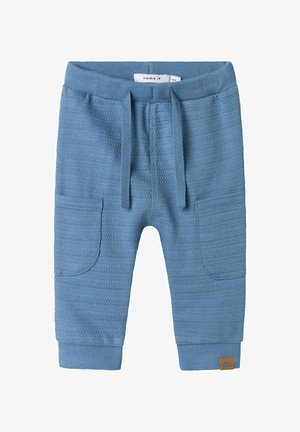Pantaloni per bambini in maglia blu con un motivo testurizzato, vita elastica, cordoncino e tasche laterali. Presenta un'etichetta marrone con il marchio.