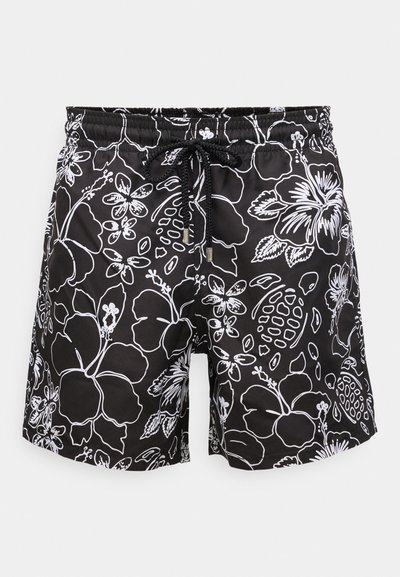 Čierne plavky s bielymi kvetinovými a želvičkovými vzormi a čiernym sťahovacím pásom na elastickom páse.