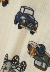 Medvilninė medžiaga su spalvingomis iliustracijomis apie senovinius automobilius. Fonas yra kreminės spalvos su tekstūruotomis juostomis. Automobiliuose yra mėlynos ir žalios spalvos modeliai.