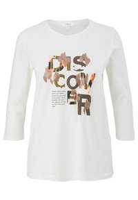 White long-sleeve shirt featuring bold text "DISCOVER" in various colors and patterns, with a graphic design and soft cotton material.