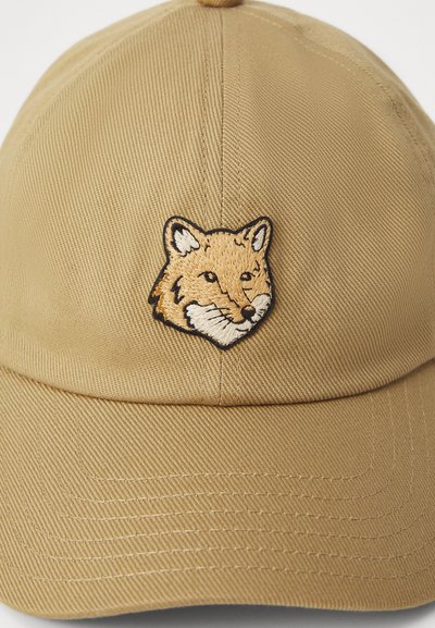 Καστανό βαμβακερό καπέλο μπέιζμπολ με κεντημένη κεφαλή αλεπούς στο μπροστινό μέρος. Το καπέλο έχει δομημένο σχήμα και υφή επιφάνειας.