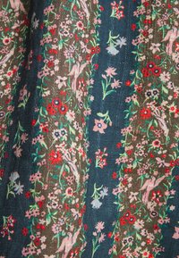 Tmavě modrá tkanina se květinovým vzorem s růžovými, červenými a zelenými květy. Obsahuje podrobné ilustrace ptáků a listů.