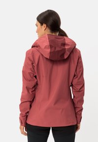 Giacca bordeaux impermeabile con cappuccio, caratterizzata da una texture liscia, una silhouette aderente, polsini elasticizzati e un design sobrio.