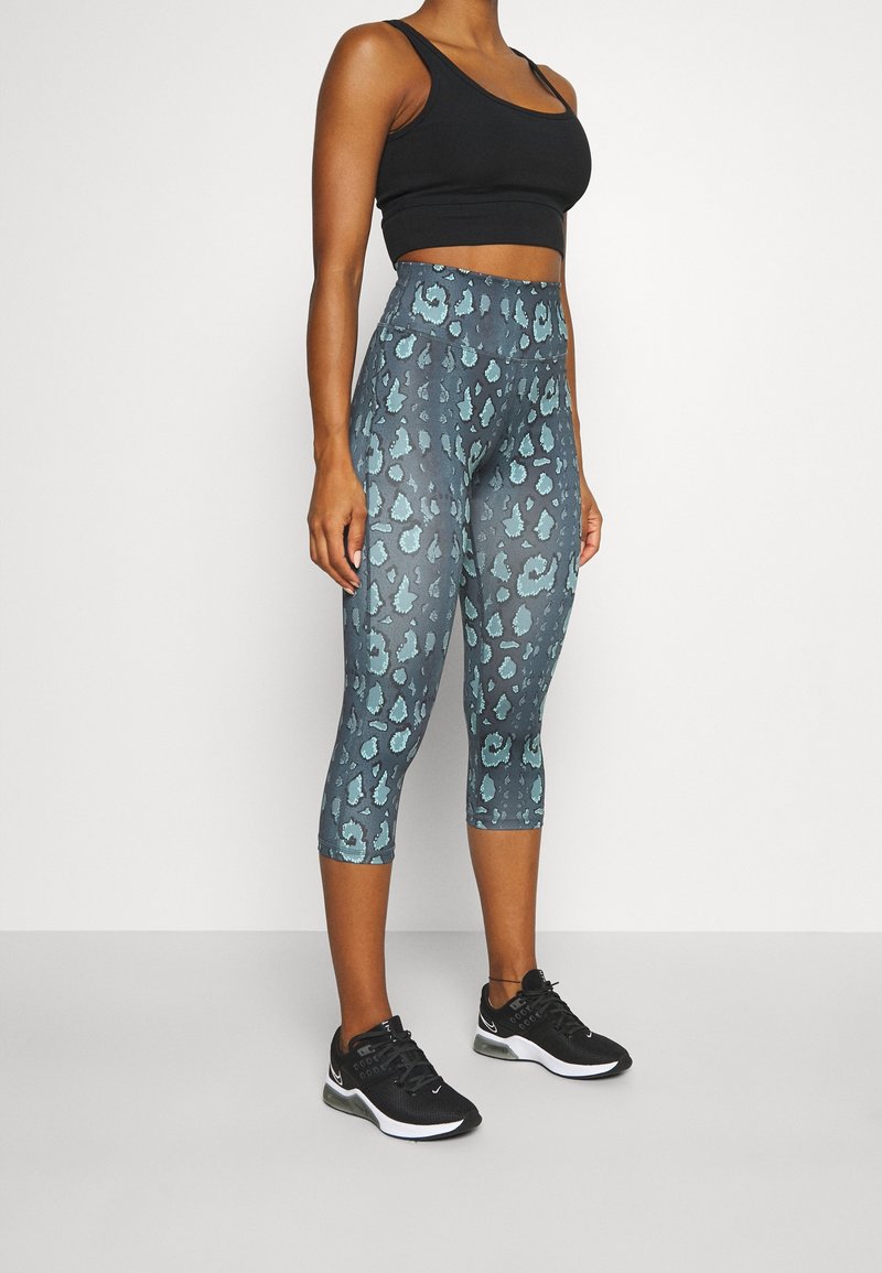 Leggings capri aderenti di colore blu-grigio con un motivo leopardato, dotate di una vita alta e di un tessuto morbido e elasticizzato.