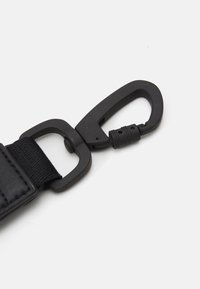 Zwarte clipriem met een duurzame plastic clip, een gladde textuur en een flexibele scharnier voor een veilige bevestiging.