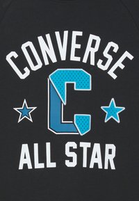 Felpa nera con testo bianco "CONVERSE", una grande "C" blu con un motivo testurizzato e due stelle blu. Testo "ALL STAR" sottostante.