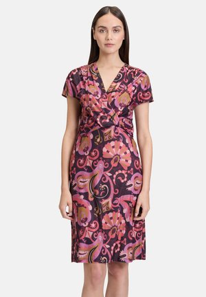 Robe portefeuille à manches courtes en tissu violet foncé avec des motifs floraux et paisley vibrants en rose. Dotée d'un détail de taille noué et d'une coupe au genou.