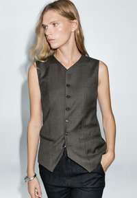 Ciemnoszara kamizelka bez rękawów z dekoltem w kształcie V, pięcioma guzikami i dwiema kieszeniami z przodu. Teksturowana tkanina z dopasowanym krojem.