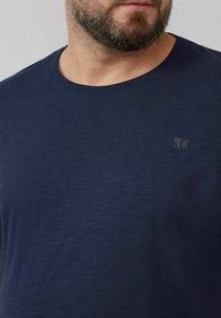 Navyblaue Kurzarm-T-Shirts aus weichem Stoff, mit rundem Ausschnitt und einem dezenten Logo auf der oberen linken Brust.