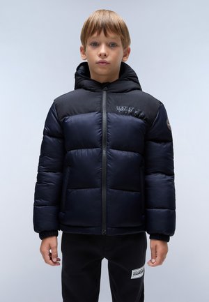 Chaqueta azul marino acolchada con una pieza negra en los hombros, cuenta con cierre de cremallera, capucha y puños elásticos. Detalle del logo en el pecho. Pantalones negros visibles por debajo.